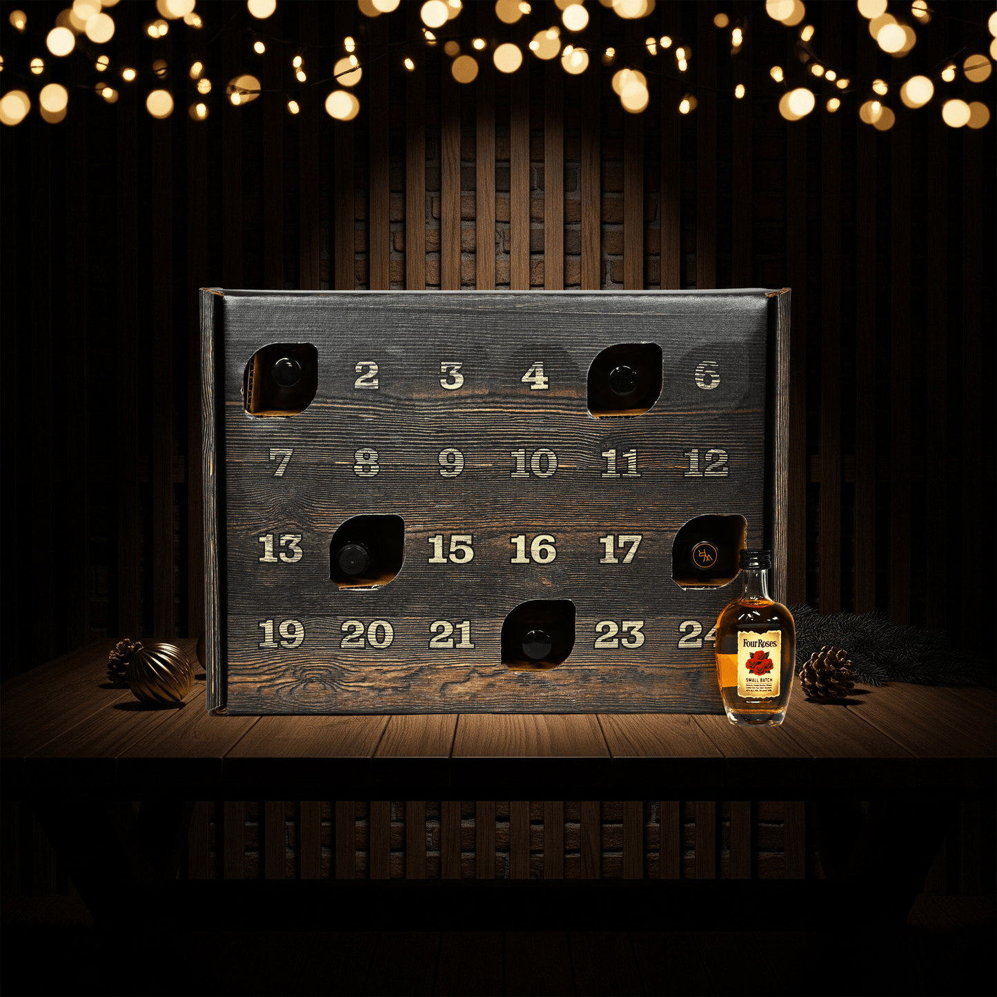 advent calendar with numbered compartments on a wooden surface, accompanied by a bottle of whiskey.